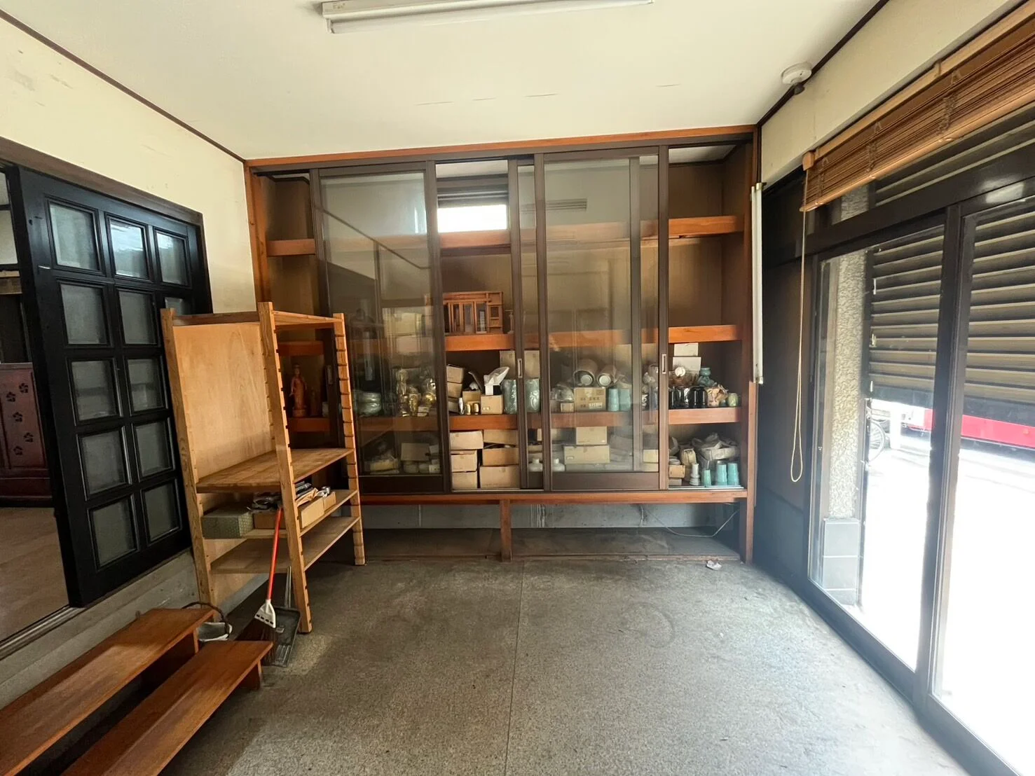 片付け前：食器や箱が棚いっぱいに収められた部屋