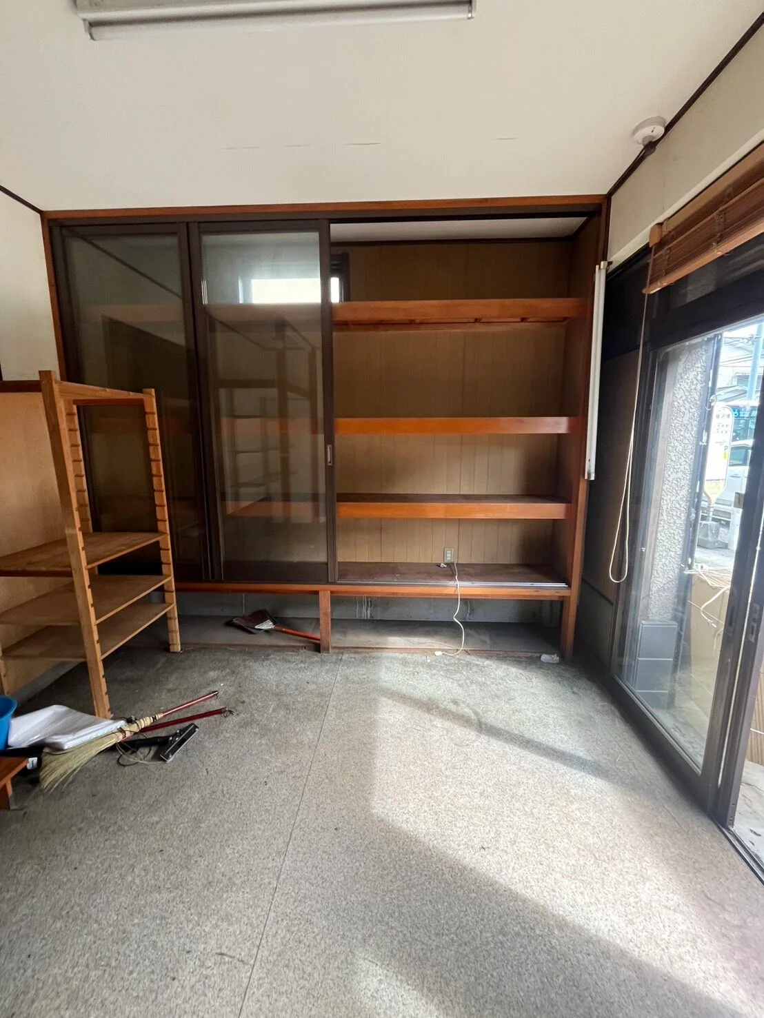 片付け後：棚の中が空になり、すっきり片付いた部屋